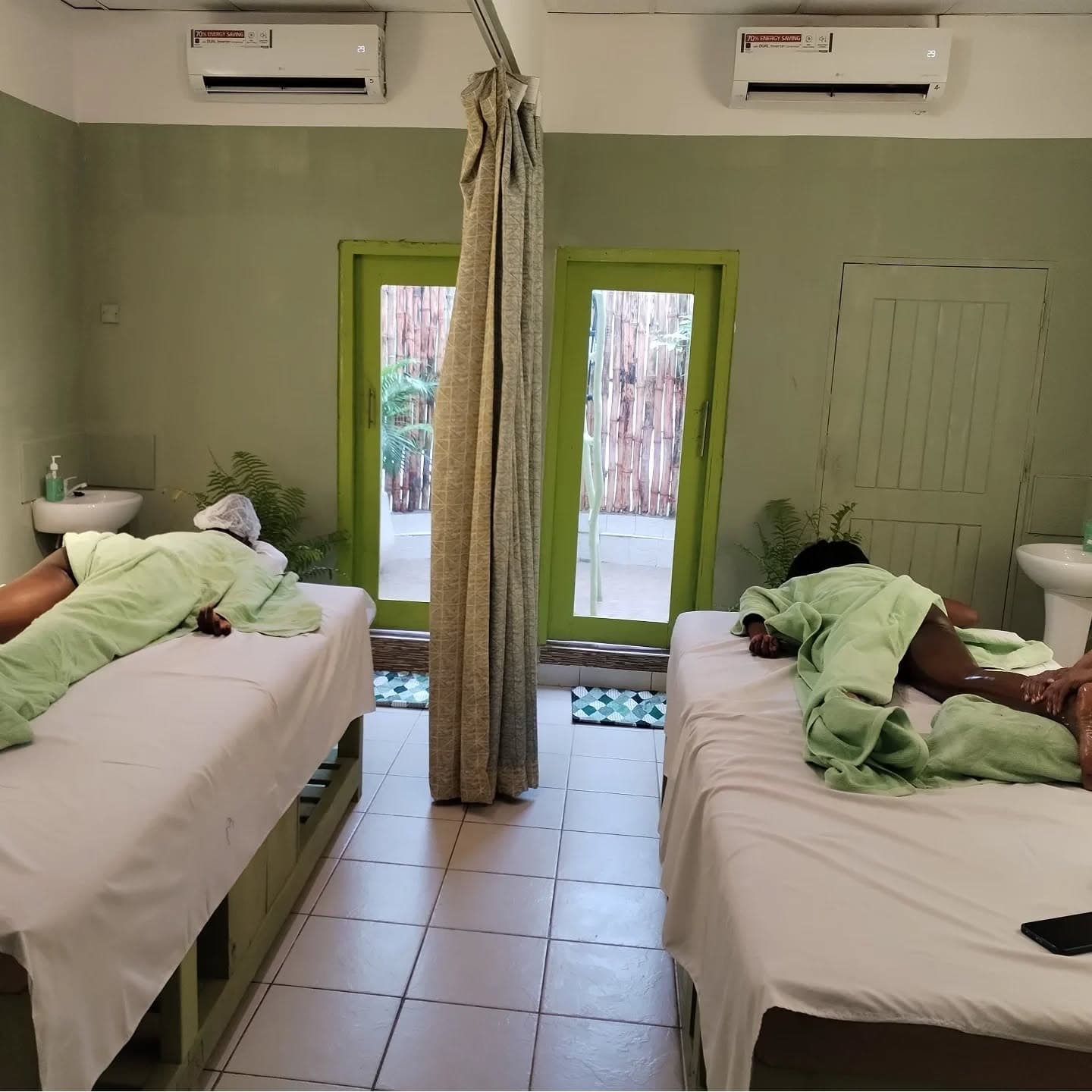 Subtle view of Malaika Lotus treatment room with massage beds and sage details